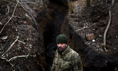 A Ukrainian serviceman stands in a trench near the frontline in Donetsk region