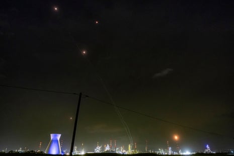 Trails and lights from missile defence interceptors are seen in the sky, as excess gas is burned at the oil refinery in Israel's northern city of Haifa late on Thursday.