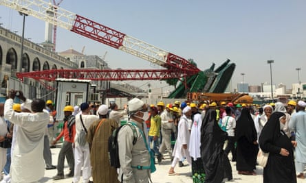 Muslim pilgrims walk near a construction crane which crashed in the Grand Mosque in the Muslim holy city of Mecca