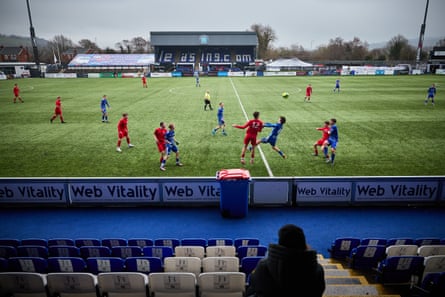 Players head the ball at an otherwise empty ground