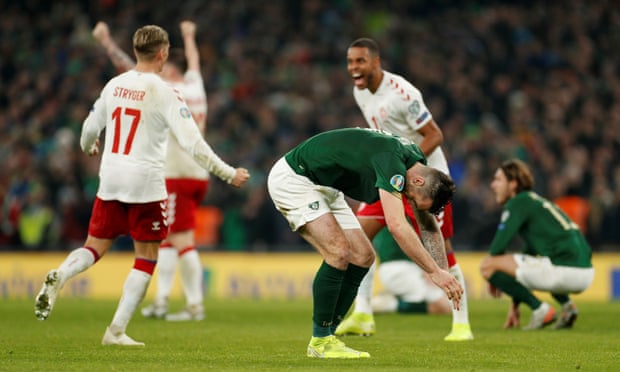 Shane Duffy sinks to the ground as Denmark’s Jens Stryger Larsen and Mathias Jorgensen celebrate at the final whistle.