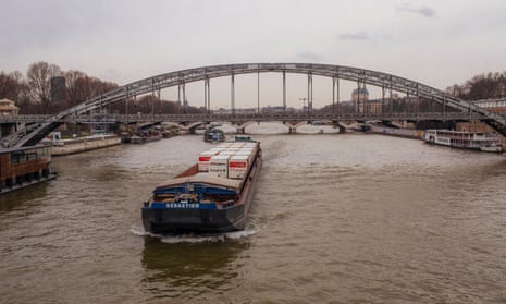 A container barge transporting Franprix grocery goods travels along the river Seine to the centre of Paris.