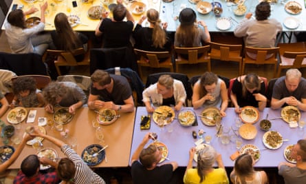 An aerial shot of people sitting around rectangular communal dining tables at Absalon, in Denmark