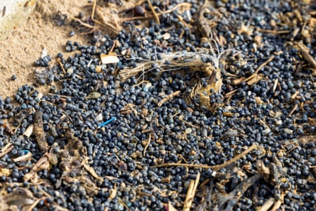 Closeup of hundreds of plastic beads on the beach