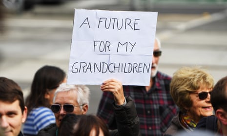A man hold a sign at an climate change protest in Melbourne. The burden of the climate crisis will fall primarily on younger generations.
