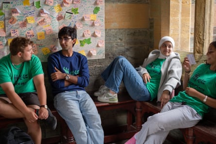 Four attenders sat talking in frnot of pinboard