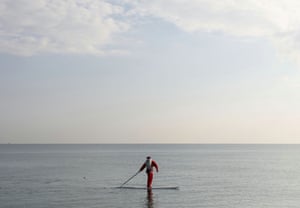 A man dressed as Santa Claus paddles on a board in Larnaca, Cyprus