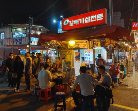 Diners eating at street barbecue restaurants in Jongno 3-ga.