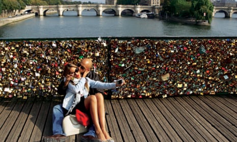 Lovers take a selfie on the lock-covered Pont des Art in Paris.