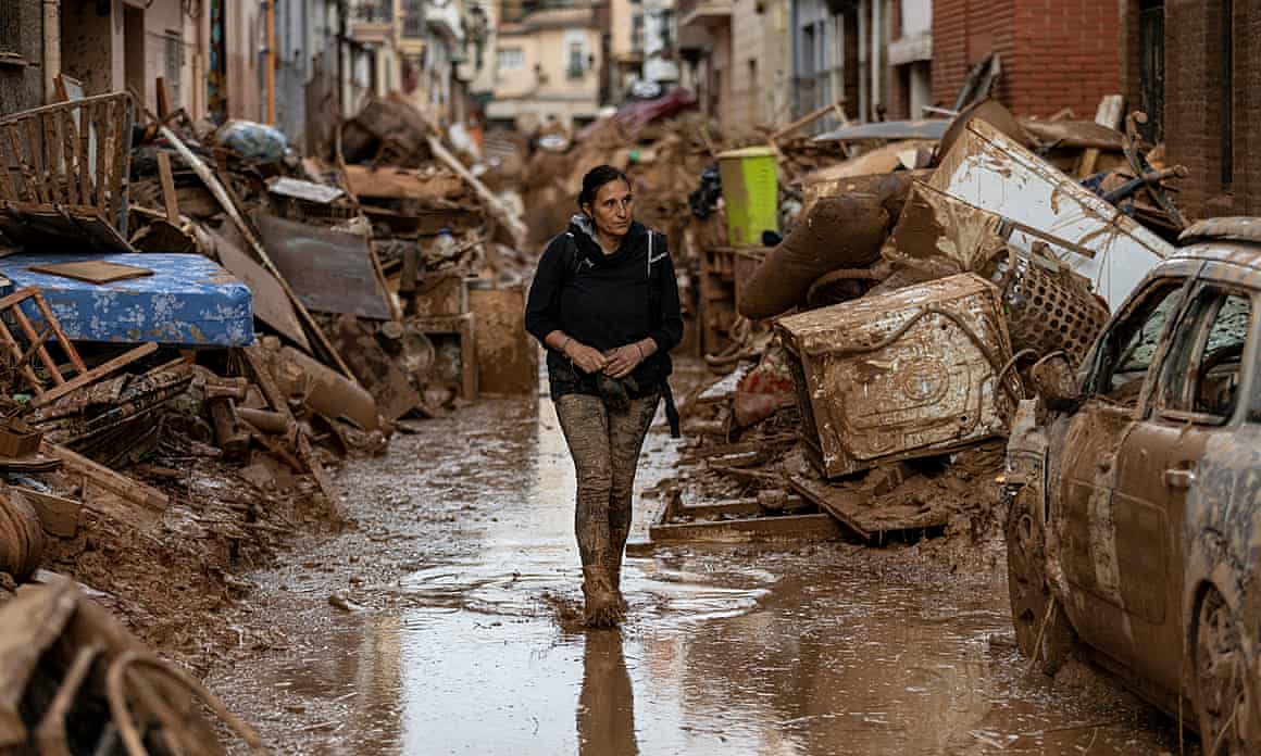 A woman walks through a flooded street in Valencia, Spain.