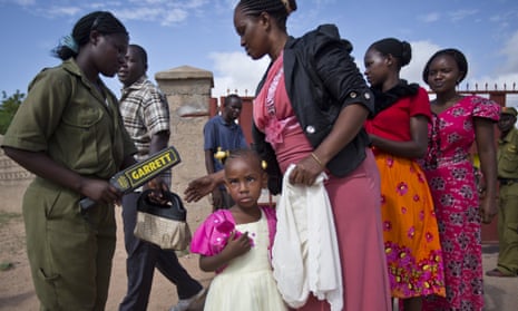 Christians are scanned with a metal detector outside the Our Lady of Consolation church, which was attacked with grenades by militants , in Garissa, Kenya