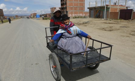 A woman is transported on a tricycle to a polling station to vote in El Alto.