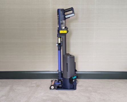 Side on view of the Shark IA3241UKT vacuum cleaner against a grey wall and on a grey living room carpet.