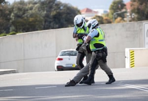 Police arrest an Extinction Rebellion protester who blocked the road in front of Parliament House, Canberra