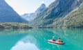 Couple canoeing on pristine blue lake in Norway.