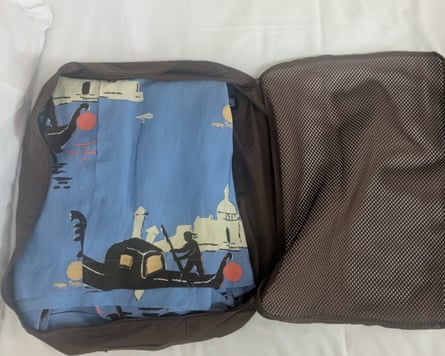 A folded shirt packed in to a black packing cube.