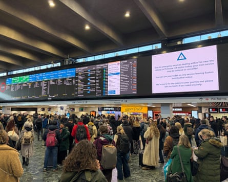 passengers on concourse and board saying services disrupted