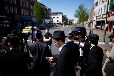 Members of the Jewish community gather near the scene of the stabbing.