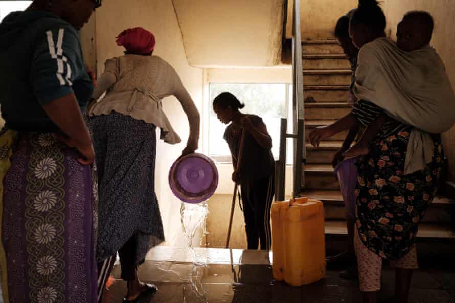Women, who fled the violence in Ethiopia’s Tigray region, clean human waste on stairs after sunrise at May Weyni secondary school, that turned in to a Internal Displaced People (IDP) camp registering 10500 people, in Mekele, the capital of Tigray region, Ethiopia, on June 23