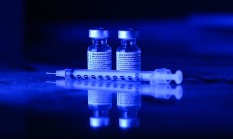 Two vials of Covid vaccine and a needle