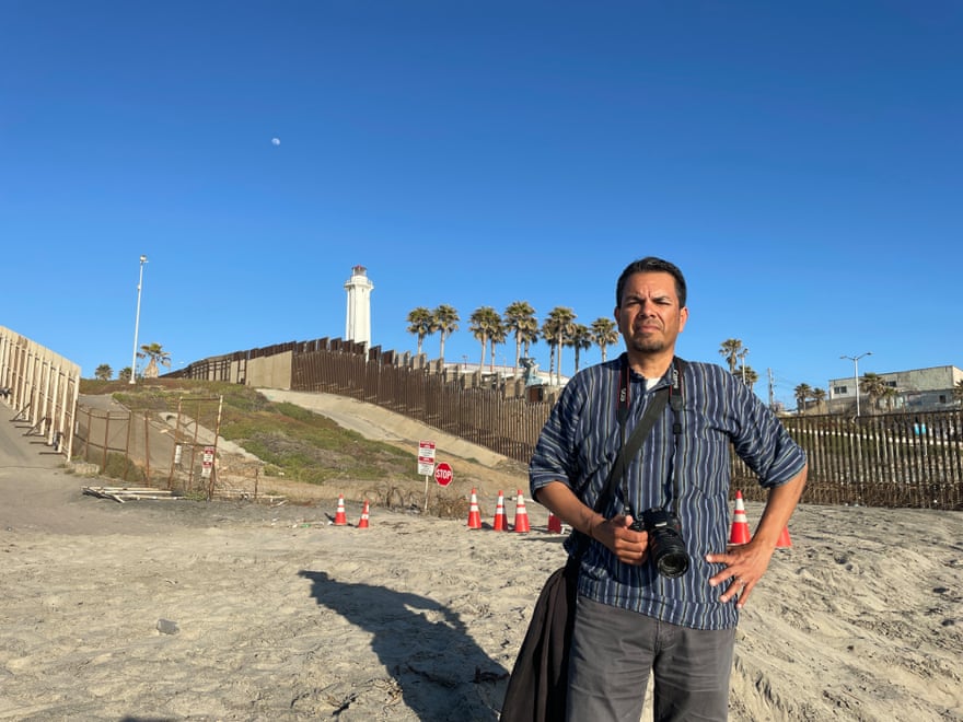 Man stands in front of border fence