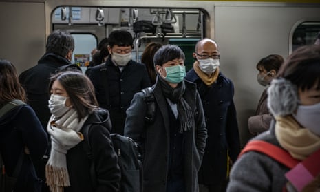 Commuters wearing face masks disembark from a train on Tuesday in Tokyo, Japan.