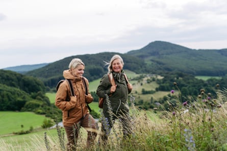 Mature daughter and her mom on hiking trip in nature. Windy weather.