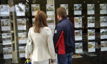 A couple looking in an estate agent's window