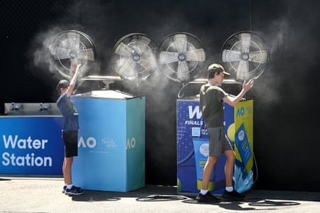 Spectators stand in front of misting fans