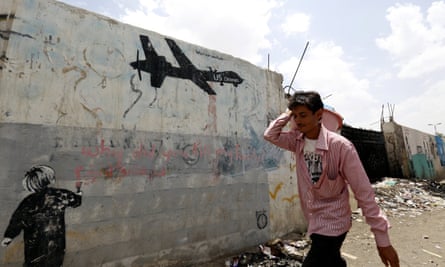 A man walks past graffiti in Yemen protesting against US drone strikes