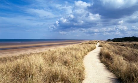 Path through marram grass by the sea on a sunny day at Holme-next-the-Sea, Norfolk, UK.