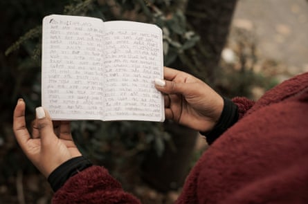 Picture of the woman’s hands holding open her diary, in which she has written