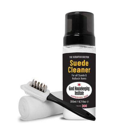 A bottle of Scratch Doctor Suede Cleaner which is white with black label and black lid. There is a rolled up cloth and cleaning brush to the right.