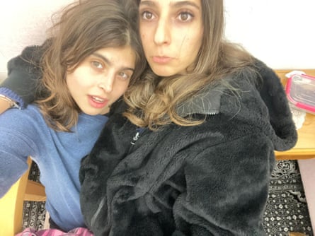 Two young women with long brown hair taking a selfie from above.