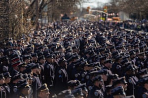 Hundreds of police officers standing to attention next to a road