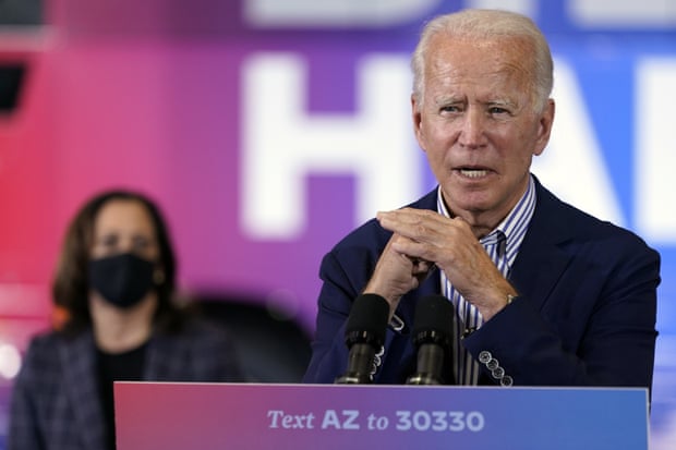 Joe Biden speaks as Kamala Harris listens in Phoenix, Arizona, on 8 October.
