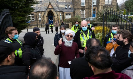 A local community leader speaks to the crowd of parents outside a Batley Grammar School, West Yorks, after a teacher allegedly showed derogatory caricatures of the Prophet Muhammad.
