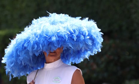 A racegoer wearing a hat arrives ahead of the day's races.