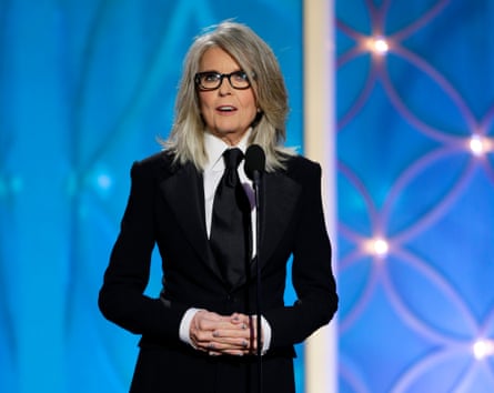 Diane Keaton accepting an award in 2014 wearing a dark suit and dark tie