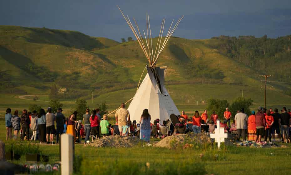 Hundreds of people gather for a vigil in a field where 751 human remains were discovered in unmarked graves by the Cowessess First Nation at the site of the former Marieval Indian residential school in Canada on 26 June. It was the second such shock discovery in less than a month. 