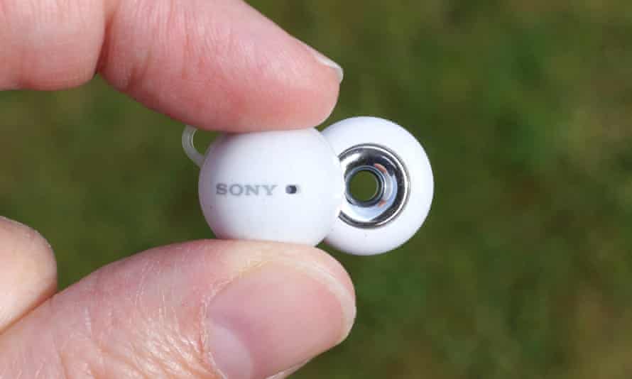 The Sony LinkBud held between two fingers showing the hole in the centre of the speaker.
