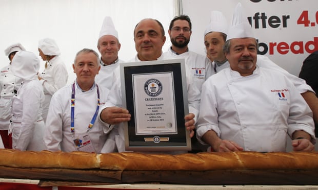 French and Italian bakers pose with the longest baguette in the world.