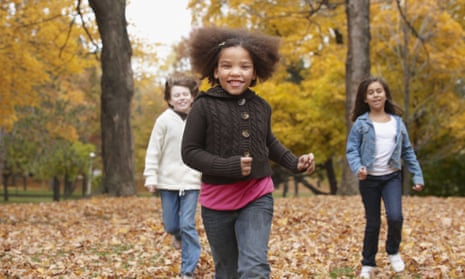 Children run in a park in autumn in Toronto, Canada