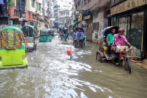Rickshaws travel through a flooded street