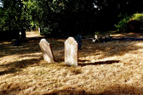 Two gravestones on parched land.