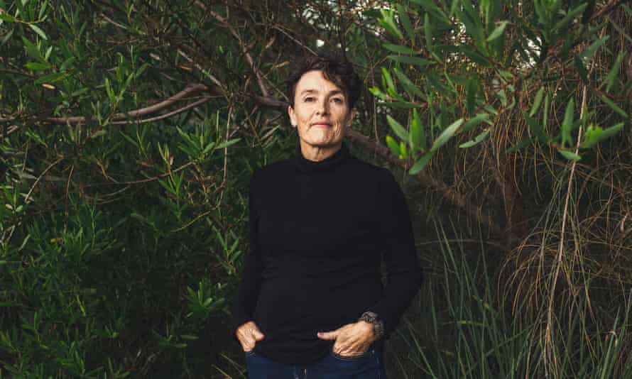 Edwina Robinsons wears a black top and jeans in front of tall, thick green plants