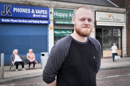 Corey Barron standing on a street of shops