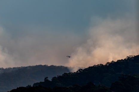 A waterbombing helicopter flying over a bushfire in the Hunter region at the weekend