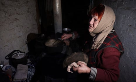 An elderly woman cooks in a basement where she lives in the town of Siversk, Donetsk region.