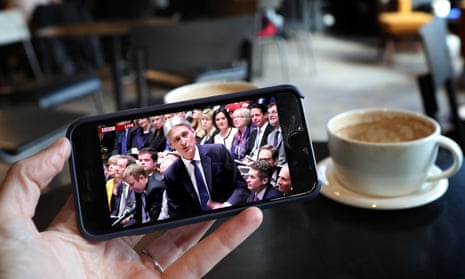 A smartphone user watches Philip Hammond deliver his budget speech